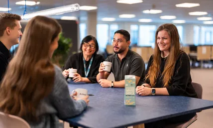 personer som sitter vid ett bord på ett kontor