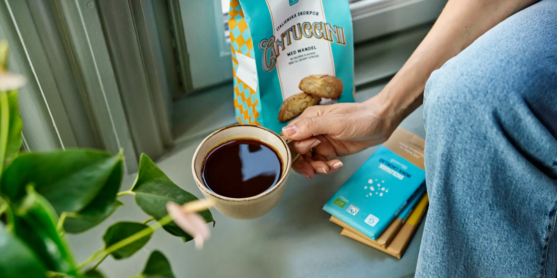Person som dricker kaffe, chokladkakor i bakgrunden