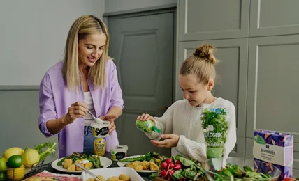 Kvinna och barn lagar mat i ett kök