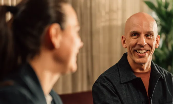 Manlig kollega sitter och ler