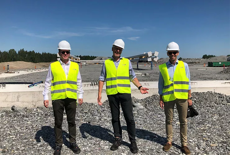 Medarbetare framför byggarbetsplatsen för Dagabs nya lager i Bålsta